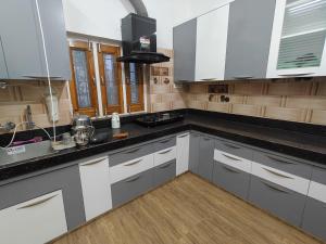 a kitchen with white cabinets and a black counter top at Bikaner House in Bikaner