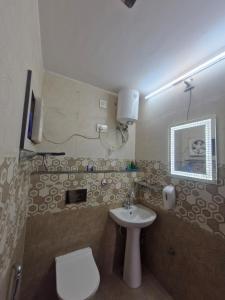 a small bathroom with a toilet and a sink at Bikaner House in Bikaner