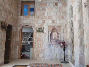 a room with a stone wall with a fan at الشاميه سانت كاترين in Saint Catherine