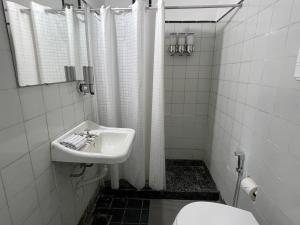 un bagno bianco con lavandino e WC di Catalina House ad Alta Gracia