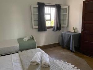 una stanza con due letti, un tavolo e una finestra di Catalina House ad Alta Gracia