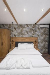 a bedroom with a white bed with a stone wall at Goga Otel in Sarıyer +291 photos