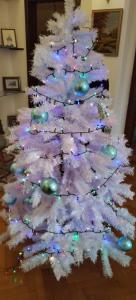een witte kerstboom met lichten erop bij Barok Apartments in Braşov