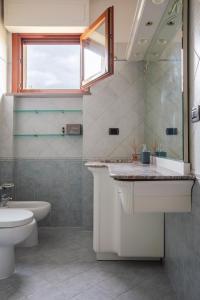 ein Badezimmer mit Waschbecken und Toilette und einem Fenster in der Unterkunft Centrale con panorama. in Siena + 20 Fotos