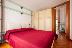 ein Schlafzimmer mit einem roten Bett in einem Zimmer in der Unterkunft Centrale con panorama. in Siena