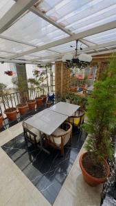 een patio met een tafel en stoelen en potplanten bij Hotel Apple Regency in Shimla