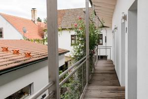 a balcony with a wooden walkway between two buildings at Weingut Herzinger in Franzhausen