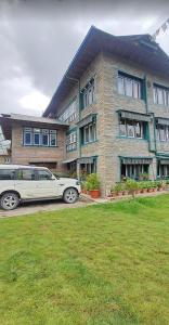 a white car parked in front of a building at Everest hotel in Phāphlu