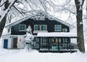 a house covered in snow in the yard at Sugi Lodge in Hakuba