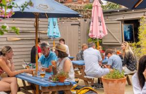 a group of people sitting at a table under an umbrella at The Bugle Coaching Inn in Yarmouth