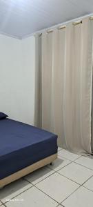 a bedroom with a bed and curtains on the floor at Fundilhos House in Rio das Ostras