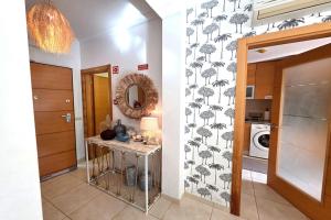 a hallway with a table and a wallpaper with palm trees at SV Villa Burgau in Burgau