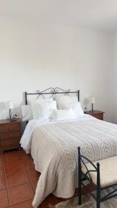 a bedroom with a large bed with white sheets and pillows at La Viñita in El Paso