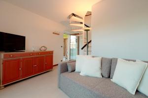 a living room with a couch and a flat screen tv at Trieste - Villa Prosecco in Prosecco