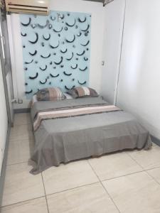 a bed in a room with a wall at Appartement les Alizés in Les Abymes