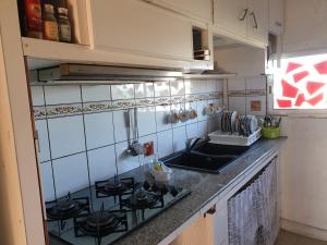a kitchen with a stove and a sink at Appartement les Alizés in Les Abymes