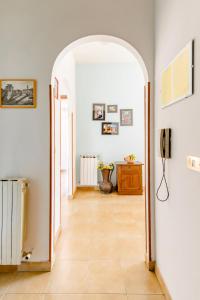 a hallway with an archway and a phone on a wall at Le Anfore in Marino