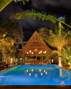 een resort met een blauw zwembad in de nacht bij Hostel 197 in Nungwi
