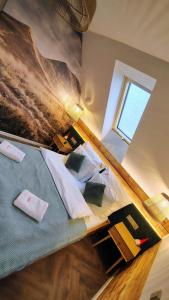 ein Schlafzimmer mit einem Bett mit Kissen und einem Fenster in der Unterkunft Łykolańczyk-Chatki z JACUZZI in Polańczyk