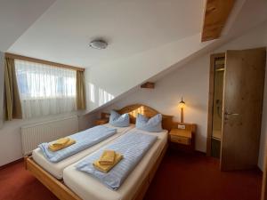 een slaapkamer met 2 bedden en gele handdoeken. bij Hubertushof Ferienwohnungen in Gerlos