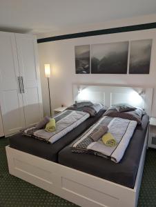 twee eenpersoonsbedden in een slaapkamer met een groot bed bij Apartment "Waldrand" mit Balkon und Pool - Renoviert 2026 in Bad Essen