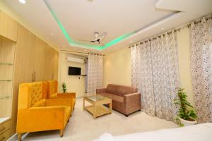 a living room with a couch and a chair at AeroStay Comfort Inn - Near Ranchi Airport in Rānchī
