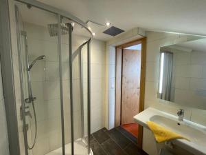 een badkamer met een douche en een wastafel bij Hubertushof Ferienwohnungen in Gerlos +42 foto's