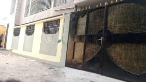 a building with a large black and white door at Apparemment 2 chambres- Lemba Salongo in Kinshasa