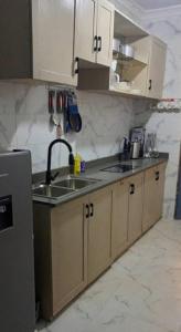 a kitchen with white cabinets and a sink at Apparemment 2 chambres- Lemba Salongo in Kinshasa