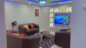 a living room with couches and a flat screen tv at Apparemment 2 chambres- Lemba Salongo in Kinshasa