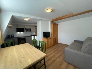 een woonkamer met een tafel en een bank bij Hubertushof Ferienwohnungen in Gerlos
