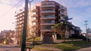 a tall apartment building with stairs in front of it at Departamento "B" en Edificio Huarpes Gesell in Villa Gesell