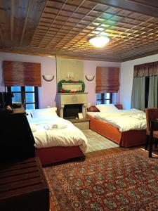 a hotel room with two beds and a fireplace at Ελευθερία in Asprangeloi