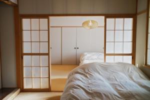 a bedroom with a bed and sliding glass doors at Shoe Cream Inn Higashikawa in Higashikawa