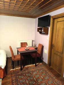 a room with a table and chairs and a television at Ελευθερία in Asprangeloi +19 photos