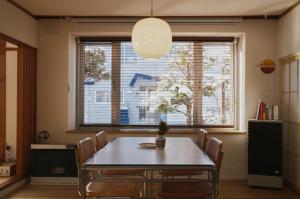 a dining room with a table and chairs and a large window at Shoe Cream Inn Higashikawa in Higashikawa