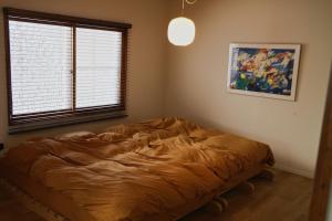 a bedroom with a bed in a room with a window at Shoe Cream Inn Higashikawa in Higashikawa