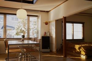a bedroom with a bed and a table and chairs at Shoe Cream Inn Higashikawa in Higashikawa