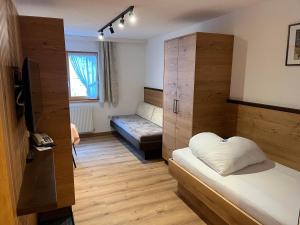 a room with two beds and a couch in it at Hotel Garni Tyola in Ischgl