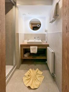 a bathroom with a sink and a mirror at Hotel Garni Tyola in Ischgl +13 photos