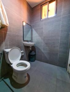 a bathroom with a toilet and a sink at Baao Las Estrellas in Baao