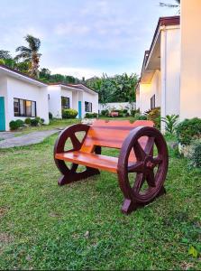 a wooden bench sitting in the grass next to a building at Baao Las Estrellas in Baao