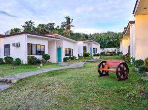 a red bench in the yard of a house at Baao Las Estrellas in Baao