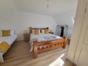a bedroom with two beds with yellow pillows at The Lake House, cong in Cong