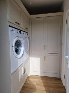 a white laundry room with a washer and dryer at The Lake House, cong in Cong