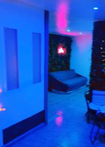 a living room with a couch and blue lights at Paris Rosny 2 - Appartement Love Room with Jacuzzi in Rosny-sous-Bois