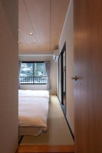 En eller flere senge i et værelse på AURA YUZAWA Apartment Hotel - Spacious 1Bedroom Apartment with Large Living Room Sleeps 4 to 6, Bedroom with 2-Double Beds, Living Room with 1-Double Bed & 1-Sofa Bed