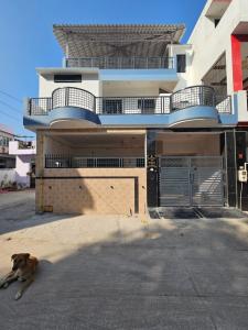 a dog laying on the ground in front of a building at AnjuShyam HomeStay in Agra