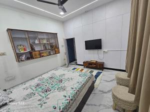 a room with a bed and a tv in it at AnjuShyam HomeStay in Agra