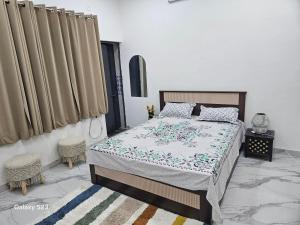 a bedroom with a bed and two chairs at AnjuShyam HomeStay in Agra